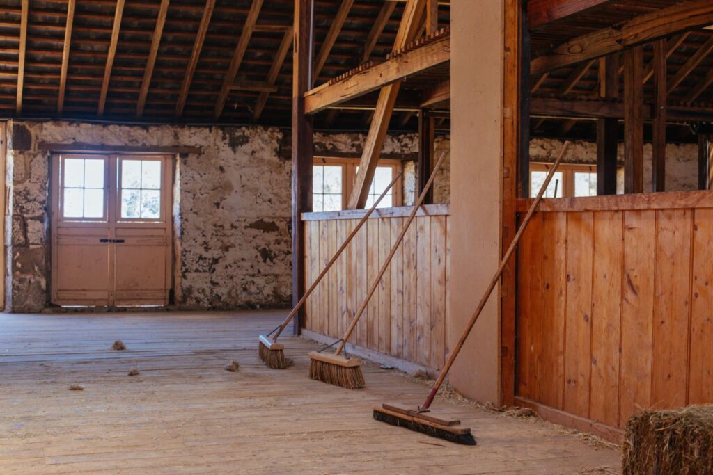 Restored barn interior with wooden walls, clean flooring, and natural light—example of successful barn rehab in New York.